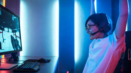 Side View Shot of Professional Gamer Playing and Winning in First-Person Shooter Video Game on His...
