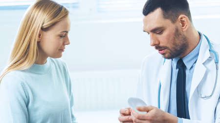 Plastic Cosmetic Surgeon Shows Female Patient Breast Implant Samples for Her Future Surgery.の写真素材