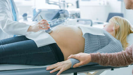 In the Hospital, Close-up Shot of the Doctor Performs Ultrasound Sonogram Procedure, Pregnant Female...