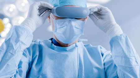 In the Hospital Operating Room Professional Surgeon Puts on Virtual Reality Glasses.の写真素材