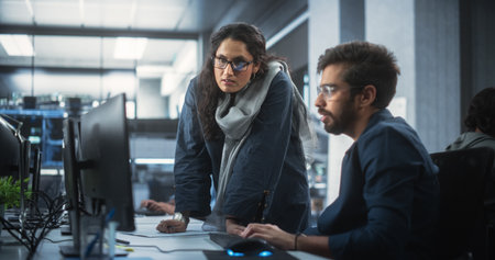 Two Diverse Multiethnic Indian Colleagues Having a Conversation While Busy Working on a Software Development Project. Engneer Talking with a Female Project Manager. Teamworkの写真素材