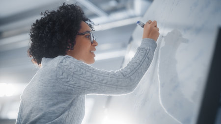 Happy Female Student Thinking about Solving Math Problem With Complicated Equation in front of Whiteboard. Education, Learning and Startupの写真素材