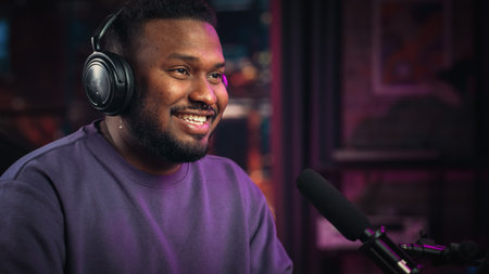 Handsome Young African American Man Talking Into Microphone While Recording Radio Show from His Loft...
