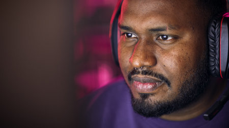 Close Up Portrait of a African American Stylish Young Man with Nose Ring Playing Online Computer...