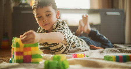 Portrait of Cute Male Asian Child Playing with Colourful Building Blocks in his Room During the Day....