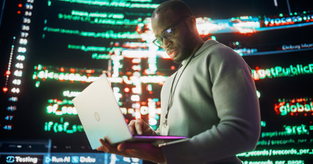 Portrait of Young Black Man Working on Laptop Computer, Looking at Big Digital Screens Glitching While Displaying Code Lines. Professional Programmer Fixing Software Bug, Dealingの写真素材