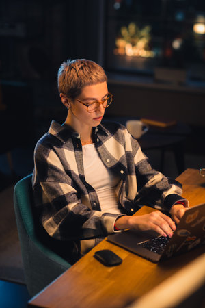 Vertical Screen: Young Attractive Woman Using Laptop Computer in Stylish Loft Apartment in the...