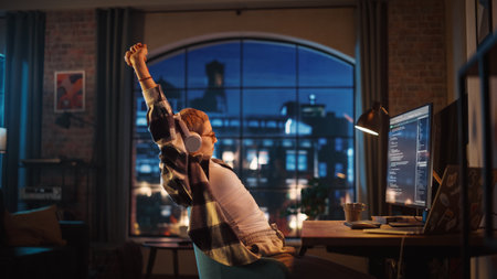 Young Woman Writing Code on Desktop Computer in Stylish Loft Apartment in the Evening. Creative...