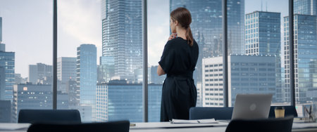 Caucasian Businesswoman Entering Her Corner Office With Big City View. Female Digital Entrepreneur Standing And Looking Out Of Window Thoughtfully,の写真素材