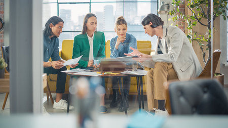 Diverse Group of People Talking in a Casual Modern Meeting Room in Office Using Laptop Computer....