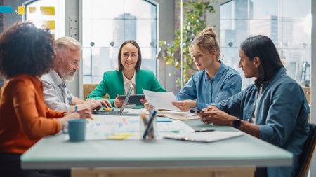 In the Stylish Modern Office Meeting Room: Diverse Group of Business Growth Marketing Professionals Use Laptop and Tablet, Discuss Project Ideas,の写真素材