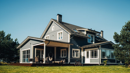 Landscape Shot with a Big Gray Residential Home on a Scenic Day with Clean Blue Sky. House in a Suburban Area with Majestic Nature.の写真素材