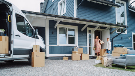 Young Family Moving to Their New Home in Residential Area. Handsome Man Unloading a Cargo Van Full of Cardboard Moving Boxes. Delivery Transportationの写真素材