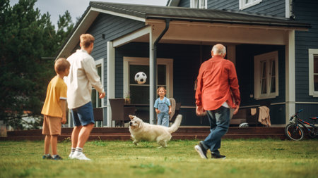 Grandfather Playing Ball with His Son and Grandchildren. Family Members Spending Leisure Time Outside with Kids and Pet Dog. People Throwing the Ball Between Each Otherの写真素材