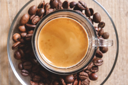 Coffee cup and coffee beans on wooden table, top viewの写真素材
