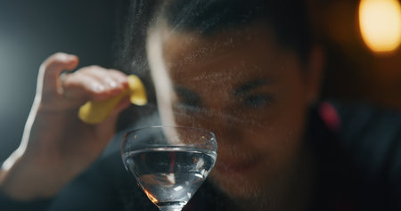 Close up of bartender pouring a martini into a glass, blurred backgroundの写真素材