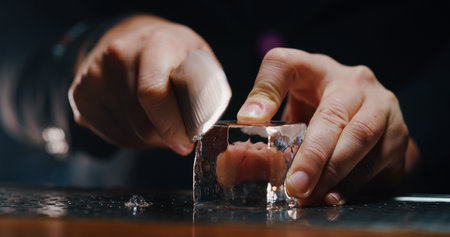 Close-up of the hands of a barman making ice cubesの写真素材