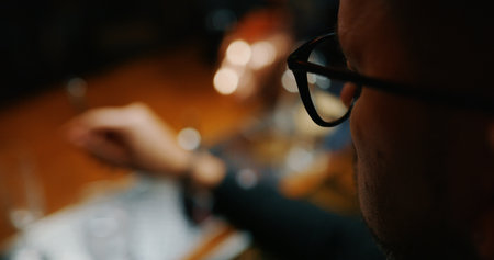 Close-up of a man sitting in a bar with glasses.の写真素材