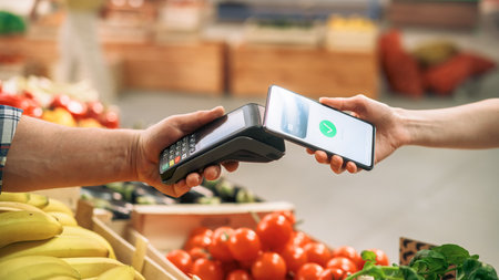 Close Up of a Customer Making a Secure Contactless Online Payment Using a Smartphone with a Credit...