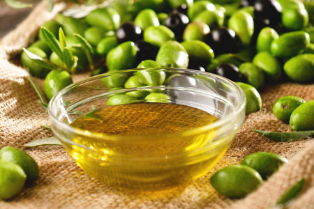 Olive oil in a glass bowl with green and black olivesの写真素材