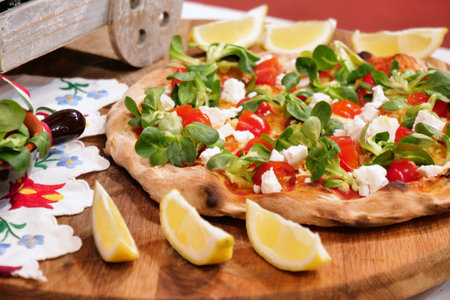 Pizza with mozzarella, tomatoes and arugula on a wooden boardの写真素材