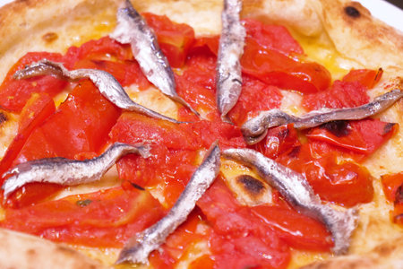 Pizza with anchovies and tomatoes, close-up, horizontalの写真素材