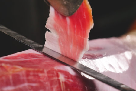 Close-up of a chef cutting a piece of jamon.の写真素材