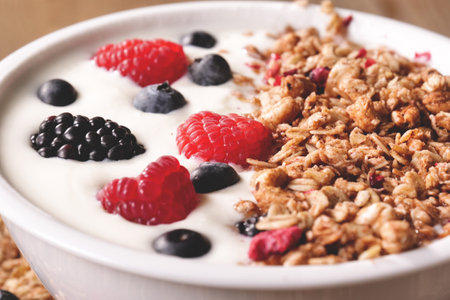 Yogurt with granola and berries in bowl, closeupの写真素材