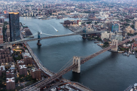 New York City Aerial Shot from a Helicopter at Daytime. Famous Buildings with Manhattan and Brooklyn Bridges. Busy Diverse Megapolis with Cars, Boats and Service Transport Moving Aroundの写真素材