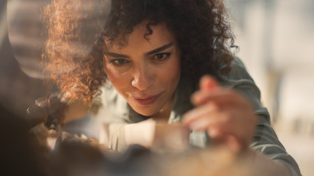 Close Up Portrait of a Talented Young Artisan Furniture Designer Using Hand Plane to Shape a Wood Bar. Carpenter Working on a Project in a Loft Studio with Tools on Walls.の写真素材