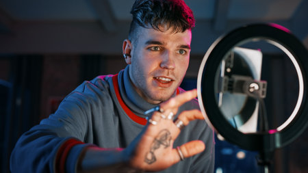 Handsome Young Man Setting Up Studio Lighting and Smartphone to Record a Dancing Routine on Video...