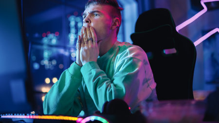 Gaming at Home: Portrait of a Gamer Wearing Headphones and Playing Online Video Game on Personal Computer. Professional Stylish Male Player Enjoying Online Multiplayer PvP Tournament.の写真素材