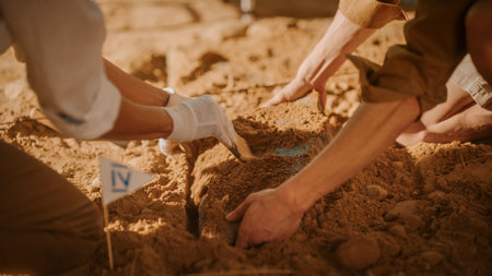 Archaeological Digging Site: Two Great Archeologists Work on Excavation Site, Carefully Cleaning, Lifting Newly Discovered Ancient Civilization Cultural Artifact, Historic Clay Tablet. Focus on Handsの写真素材