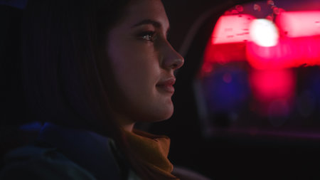 Close Up Portrait of a Female Commuting Home in a Backseat of a Taxi at Night. Beautiful Woman...
