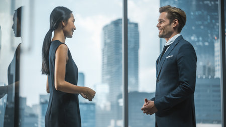 Female and Male Business Partners Meet in Office, Talk. Corporate CEO and Finance Manager Have Meeting in City Office. Businesspeople Discussing Real Estate Purchase and Marketing Project.の写真素材