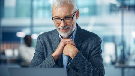 In Office: Portrait of Successful Middle Aged Corporate Businessman Working on Computer at his Desk,...
