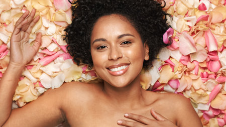Female Beauty Portrait Lying in Flower Bed. Sensual Black Multiethnic Woman with Afro Hair, Natural,...