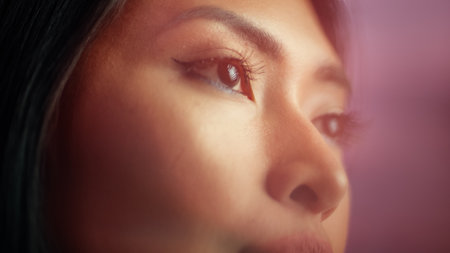 Beautiful Asian Woman with Cosmetics Mascara on Her Lush Eyelashes. Seductive Female Enjoying Her Beauty. Portrait with Focus on Deep Brown Eyes Stylish Dreamy Reflections and Lens Glaresの写真素材