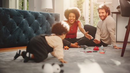 Loving Mixed Race Family Playing with Toys with Adorable Baby Boy at Home on Living Room Floor. Cheerful Mother and Father Nurturing a Child. Conceptの写真素材