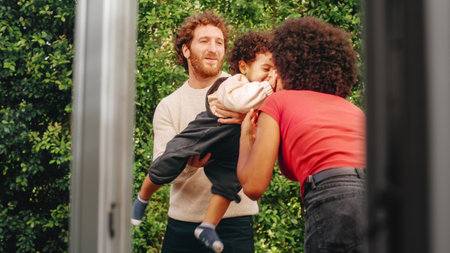 Loving Mixed Race Family Playing with Adorable Baby Boy at Modern Home, Hanging in the Garden. Cheerful Mother Nurturing a Child. Concept of Childhoodの写真素材