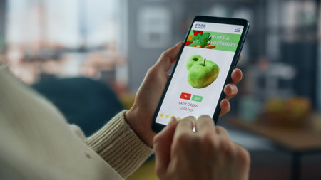 Close Up on Hands Using Online Food Shopping App on a Horizontally Held Smartphone at Home Living...