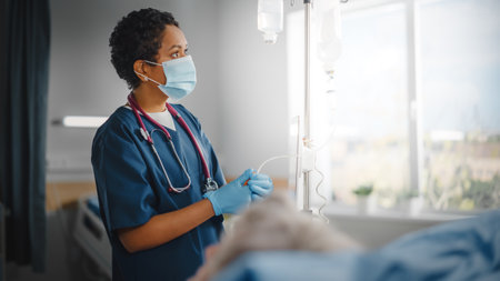 Hospital Ward: Professional Black Head Nurse Wearing Face Mask Does Checkup of Patients Vitals, Checking Heart Rate Computer, Intravenous or Ivの写真素材