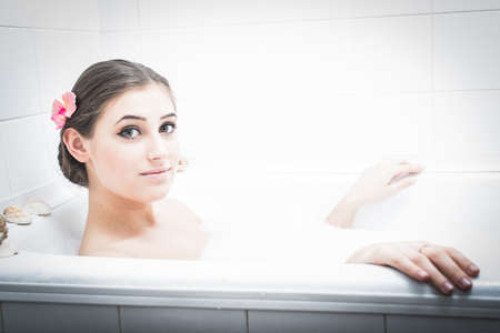 Happy bathing: brunette attractive lady having fun enjoying taking foam spa bath happy smiling and...
