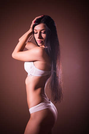 elegant buttocks: portrait of gorgeous lady black hair glamor pinup girl with excellent fitness bum happy posing in bikini or undies relaxing standing on copy space の写真素材
