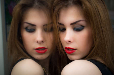 aka twins: eyes closed elegant sensual young seductive lady pinup sexy girl with silk skin, excellent hair having fun happy relaxing over mirror copy space background closeup portrait imageの写真素材
