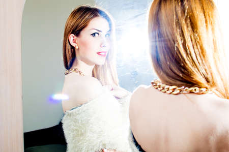 portrait of looking at camera through mirror elegant pinup pretty girl with blue eyes having fun happy smiling on light flare copy space backgroundの写真素材