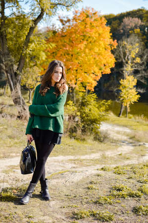 portrait of beautiful young woman with bag on autumn outdoors copy space backgroundの写真素材