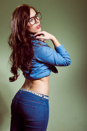 portrait of sexy hipster beautiful young lady holding hands up wearing jeans long sleeve short & trousers on light copyspace backgroundの写真素材