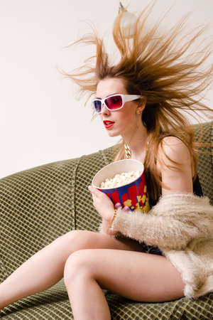 hair blown away beautiful young lady having fun watching movie in 3d glasses holding popcorn with mouth wide open & hair blown away on light copy space backgroundの写真素材