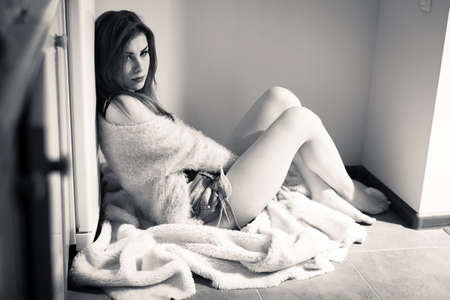 sad or calm young pretty lady sitting relaxing back to fridge on copy space background, black and white imageの写真素材